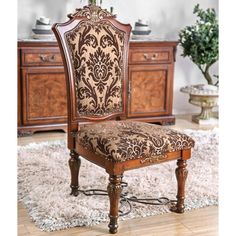 an ornately decorated chair sits on a rug in front of a dresser and sideboard