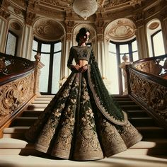 a woman in a green and gold lehenga stands on some stairs with her hands on her hips