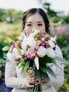 a woman holding a bouquet of flowers in her hands