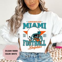 Show your team pride with this amazing Vintage Star Miami Dolphins Football Crewneck! Perfect for cooler days and game nights, this crewneck sweatshirt combines classic style and comfort, making it a must-have for any Dolphins fan. Available in a range of sizes, this crewneck offers a great fit for fans of all ages. Its versatile design makes it perfect for layering over your favorite game day outfit or wearing casually. Treat yourself or surprise a fellow Dolphins fan with this essential additi White Sports Fan Hoodie For Fan Gear, White Team Logo Hoodie For Sports Season, White Hoodie With Team Logo For Sports Season, White Team Logo Hoodie For Game Day, White Sports Season Fan Merchandise Hoodie, White Hoodie With Team Name For Fans, Game Day Hoodie With Graphic Print Fan Apparel, Game Day Hoodie With Graphic Print, White College Sports Fan Hoodie