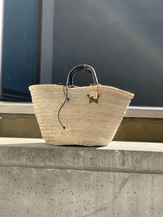 The Brigitte bag is our very modern version of the traditional Panier basket. The basket, handmade by artisans in Spain in palm leaf straw, is covered in a metallic gold mesh, and the short handles coiled in brown leather. It is lined in dark brown cotton fabric, with leather drawstring with metal star charms. The bag is finished with a Cuckoo B keychain featuring a buffalo horn star made in Vietnam, a handmade in Argentina ceramic white star and the Cuckoo B bronze tag. It is inspired on Summer Brown Cotton Fabric, Metal Star, Bag Silver, Metal Stars, White Star, Palm Leaf, Star Charms, Metallic Gold, Black Cotton