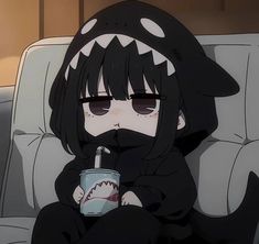 a person sitting on a couch with a cup in their hand and a shark mouth