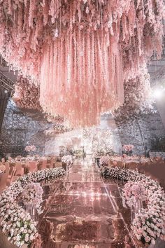 a large chandelier hanging from the ceiling in a room filled with tables and chairs