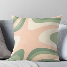 a pink and green abstract pillow on a couch