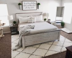 a bedroom with a large bed and white rugs on top of carpeted flooring