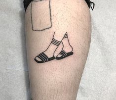 a man's leg with a small black and white tattoo design on the calf