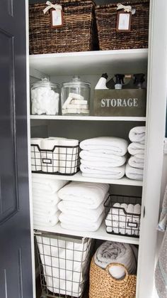 an organized closet with baskets and towels