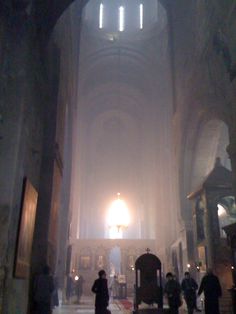 the inside of a church with people walking around