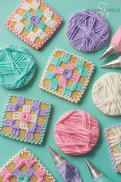 some crocheted cookies are sitting on a table with yarn and scissors next to them