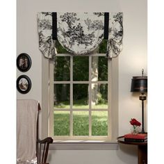 the window is decorated with black and white curtains