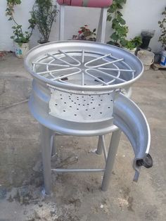 a large metal object sitting on top of a cement floor next to a planter