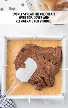 a pan filled with chocolate frosting and an ice cream scooper in the middle