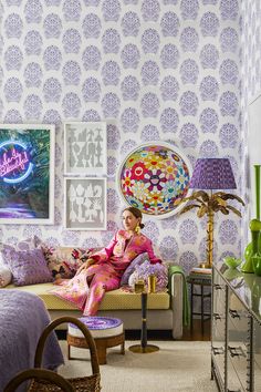 a woman sitting on top of a couch in a living room next to a lamp