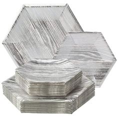 silver foil plates stacked on top of each other in front of a white background,