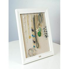 a white frame holds several necklaces and rings