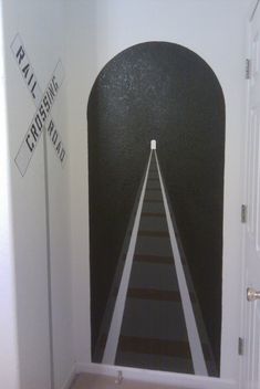 the hallway is painted with black and white stripes on the wall, leading to an exit