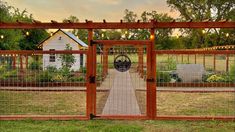 an open gate leading to a garden with lights strung up on the top and bottom