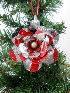 an ornament hanging from a christmas tree decorated with red, white and black ornaments