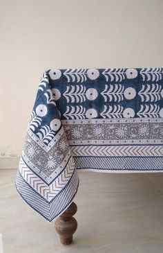 a blue and white table cloth on top of a wooden chair with an intricate design