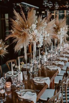 a long table with tall centerpieces filled with flowers and candles is set for an elegant dinner