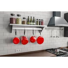 pots and pans are hanging on the wall above the stove in this modern kitchen