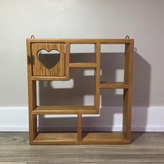 a small wooden shelf with a heart on the front and two smaller shelves below it