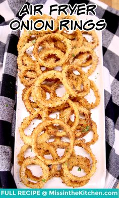 an air fryer onion rings recipe on a white plate with black and white checkered tablecloth