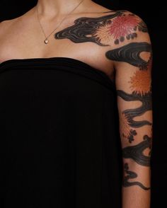 a woman with tattoos on her arm and shoulder