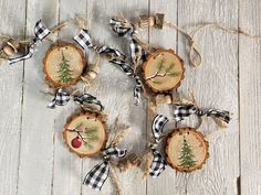 some ornaments are sitting on a white wooden table with black and white checkered ribbon