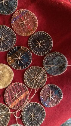 five decorative plates sitting on top of a red cloth