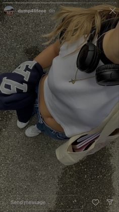 a woman with headphones on sitting in the street