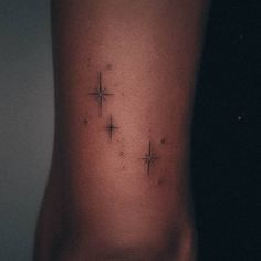 a woman's lower back tattoo with three stars