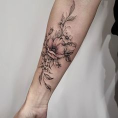 a black and white flower tattoo on the arm