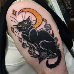 a black cat sitting on top of a flowery branch with the moon behind it