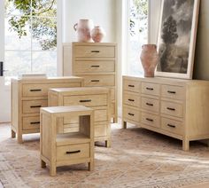 a living room scene with focus on the dresser and side tables, vases and other items