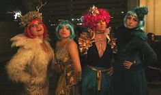 four women dressed in costumes standing next to each other