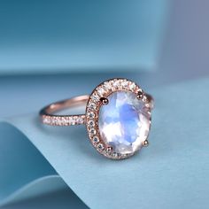 This is a natural moonstone & natural diamond engagement ring.A perfect anniversary gift, birthday gift,wedding engagement ring.Great as a gift or a anniversary ring. Ring Information Stone *10x8mm oval cut Natural moonstone. *0.3ct natural diamond. Metal * Solid 10k 14k &18k. *Color:white gold,yellow gold,rose gold. Custom Order *The main stone can be other gemstones you can imagine,any birthstone can be made.Please contact me if you need this service. *Any size *I can also design the m Gift Moonstone Ring With Halo Setting, Elegant Moonstone Anniversary Ring, Anniversary Diamond White Moonstone Ring, Anniversary Moonstone Ring With Halo, Elegant Opal Moon Ring For Anniversary, Anniversary Moonstone Ring With Rose Cut Diamonds, Luxury Gold Moonstone Ring With Large Stone, Moonstone Ring With Halo Setting, Moonstone Promise Ring With Halo Setting