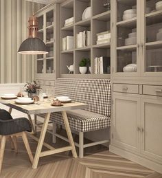 a dining room table with two chairs and a bench in front of the bookshelves