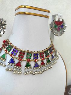 The dazzling silver earrings and choker carrying multicolor stones, is an ornament belongs to the native tribes of Afghan descendent known as Kuchi. Their chunky jewelry with a number of embellishments such as metal bells, motifs, buttons, stones, enamel inlays etc. is a delight for traditional jewelry lovers. This set has a choker and a matching chandbali. This Afghan tribal set is a perfect match for both formal and casual looks. Note: The product is handmade, so slight change might occur in t Boho Cuff Bracelet, Hand Cuff Bracelet, Boho Cuff, Afghan Jewelry, Headpiece Jewelry, Chunky Jewelry, Choker Set, Traditional Jewelry, Stylish Jewelry