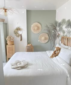 a white bed sitting in a bedroom next to two baskets