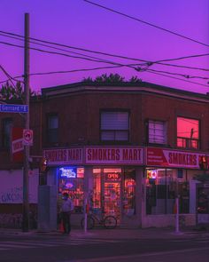 an old brick building with smokers marquee on the front and side at dusk