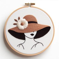 a woman wearing a hat with a flower on it's brim is featured in this embroidery pattern