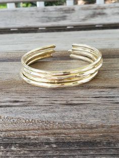 "We love our lightly hammered bangles. So, we've added a new love with our triple, heavily hammered bangles. Our first round of hammering is on the anvil, where we burn some negative energy banging away at each bangle. Our second round is on the bracelet mandrel, where we shape and add layered textures. Our final hammering is back on the anvil where we add the last dents and divets to create a stunning look that you are sure to love. Create your own set by choosing your size and number of bangle Adjustable Hoop Bangle For Everyday, Adjustable Bangle Jewelry As Gift, Adjustable Stackable Round Bracelets, Adjustable Bangle Jewelry For Gift, Adjustable Open Band Bracelet As Gift, Adjustable Open Band Bracelet For Gift, Adjustable Stackable Bangle For Everyday, Adjustable Hammered Everyday Bracelets, Handmade Adjustable Hoop Bracelets