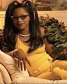 a woman sitting on top of a couch wearing glasses