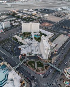 an aerial view of a city with lots of buildings and cars on the road in front of it