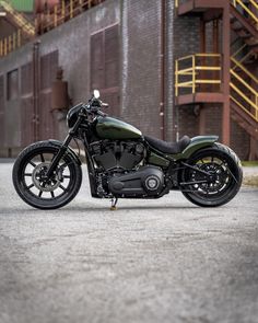 a green motorcycle parked in front of a building