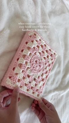 someone is crocheting a small square in pink and white