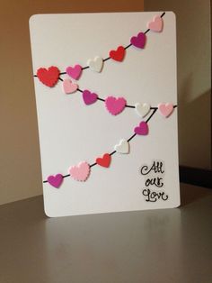 a card with hearts hanging from it on a table