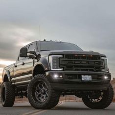 a large black truck parked on top of a parking lot