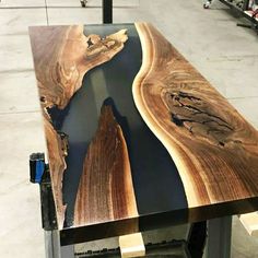 a table made out of wood and metal with a river running through it in the center